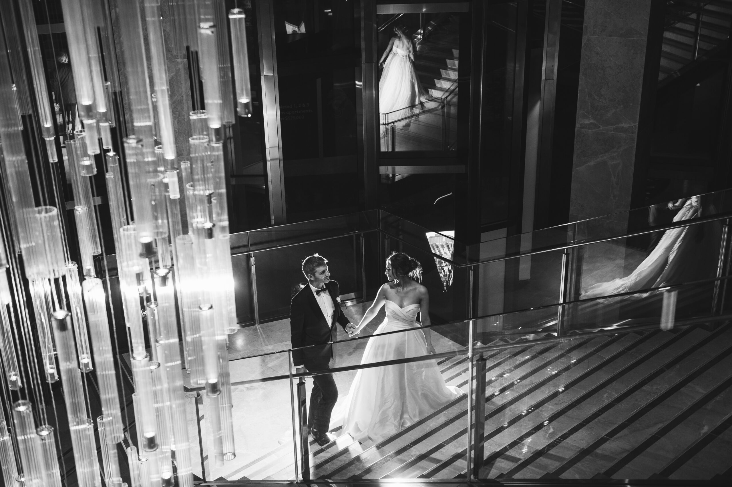 Bride and groom walk up stairs at Ritz on Carlton